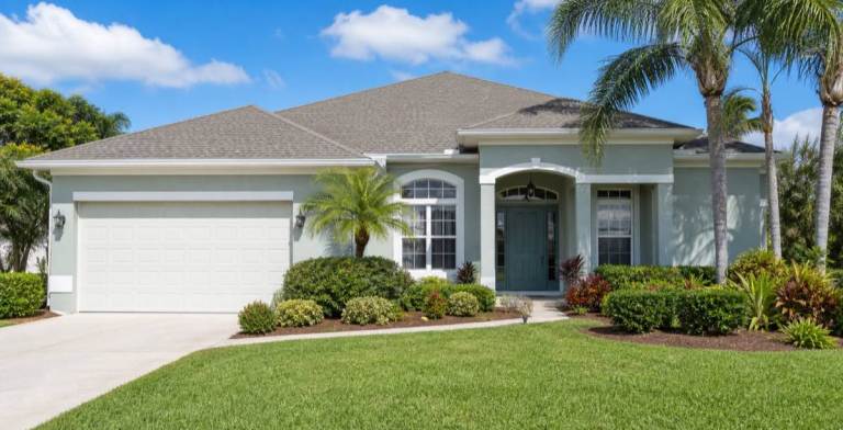 Florida stucco home exterior with painted walls and trim in bright sunlight
